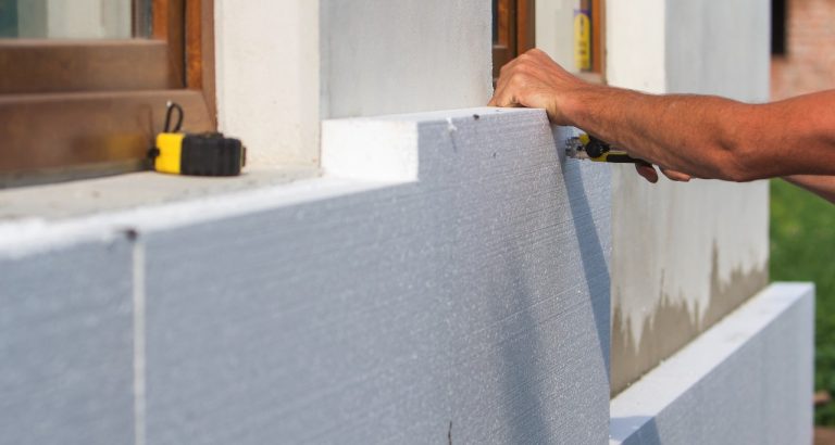 worker-hand-with-level-knife-measuring-cutting-white-rigid-polyurethane-foam-sheet worker-hand-with-level-knife-measuring-cutting-white-rigid-polyurethane-foam-sheet