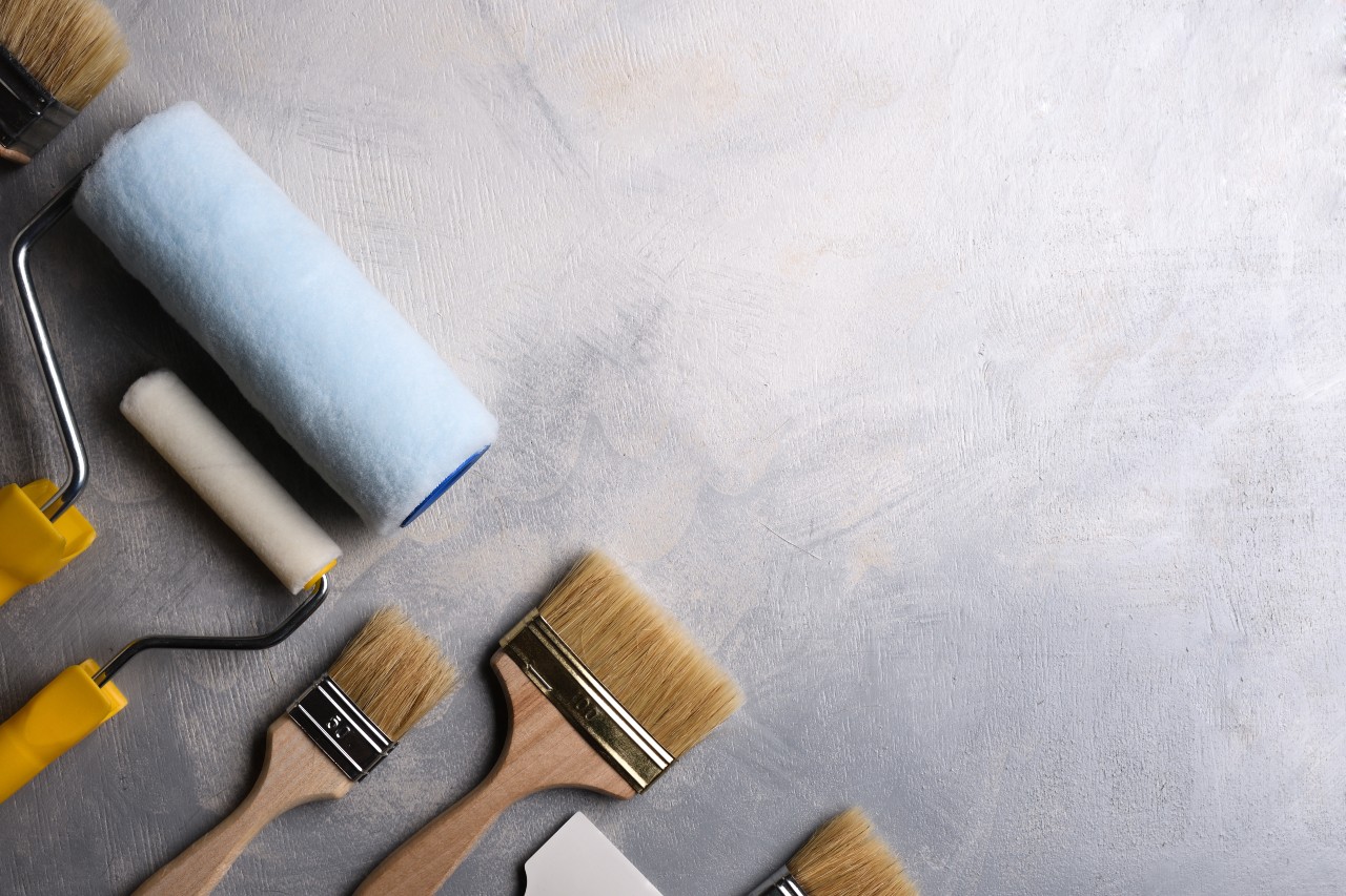 spatulas-application-putty-brushes-rollers-painting-gray-concrete-table-top-view