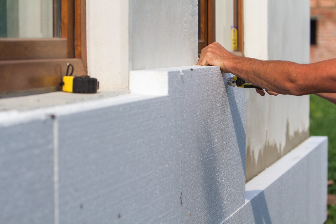 worker-hand-with-level-knife-measuring-cutting-white-rigid-polyurethane-foam-sheet